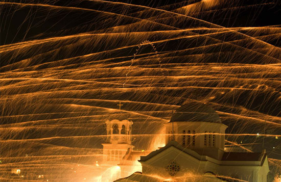 Rockets fly over bell tower of Ayios Marcos church during Greek Orthodox Easter celebrations on the eastern Aegean island of Chios in Greece late on April 26, 2008. Two rival parishes of Vrontados village fire thousands of rockets every Easter Saturday aiming at the opposing church's bell tower in a centuries-old tradition.