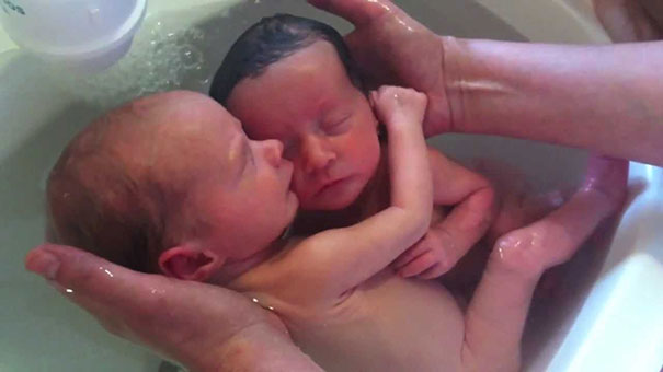 Νεογέννητα δίδυμα απολαμβάνουν το μπάνιο τους αγκαλιασμένα